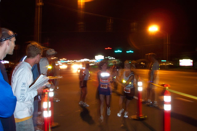 Michelle passes the reflective wrist band to Jenn