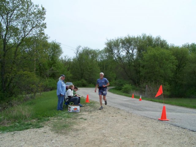 Station volunteer Mary Hopper watches veteran runner Tom Bunk of North Prairie, WI